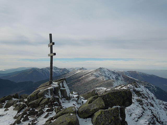 foto de la cima de dumbier un poco nevada donde se ve la cruz cristiana con dos traviesas de cirilio y metodio asi como las vistas a las montañas de alrededor